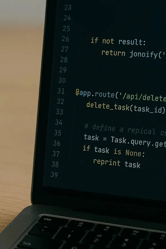 Close-up of a laptop screen showing backend code in a dark theme, representing software execution and technical implementation.